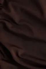 Vestido midi de punto color marrón oscuro, con diseño asimétrico de un solo hombro, frunces laterales y detalle de botones dorados en el tirante.