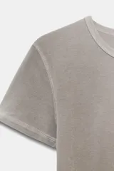 Camiseta de corte slim fit confeccionada en mezcla de algodón, con cuello redondo y manga corta. Presenta un detalle de texto bordado a contraste en la parte frontal.