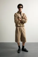 Bermuda estilo jogger de ajuste relajado, color beige, con cintura elástica ajustable mediante cordón y bolsillos delanteros.