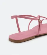 Sandalia plana de mujer color amarillo mostaza, con tiras finas que cruzan sobre el empeine y una tira con hebilla ajustable alrededor del tobillo.