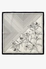 Pañuelo cuadrado con diseño dividido en dos secciones: una con estampado de líneas geométricas en ángulo y otra con ilustración botánica de flores tipo lirios en trazo negro sobre fondo crema. Presenta un borde perimetral en color negro.