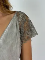 Blusa blanca de viscosa con escote en V y mangas cortas de encaje floral.