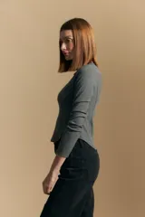 Remera blanca de manga larga con tejido acanalado, cuello redondo y corte ajustado al cuerpo. Presenta costuras verticales que definen la silueta.