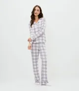 Conjunto de pijama estilo americano compuesto por una camisa de manga larga con cierre frontal de botones y solapa, y un pantalón largo con cintura elástica y lazo de ajuste. Presenta un estampado de cuadros en tonos gris y blanco.