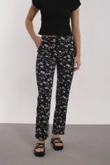 Pantalón negro con estampado de flores rosas y blancas, de corte recto.