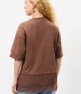 Remera marrón de algodón con cuello redondo, mangas cortas amplias y diseño de superposición con una capa inferior que presenta borde de encaje.