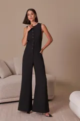 Mono largo negro sin mangas con cuello redondo, cierre abotonado frontal y corte palazzo.