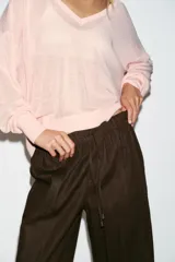 Pantalón jogger de tiro bajo color marrón, con cintura elástica ajustable con cordón, bolsillos delanteros y puños elásticos en los tobillos.