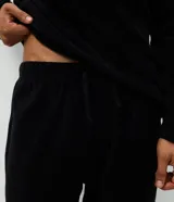 Conjunto de pijama masculino compuesto por buzo de cuello redondo y pantalón largo, confeccionado en plush de poliéster. El buzo presenta una estampa frontal del personaje Lotso de Toy Story, mientras que el pantalón cuenta con cintura elástica para mayor comodidad.
