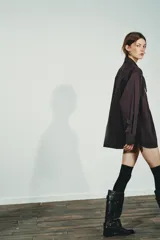 Camisa de manga larga en tejido de popelín color bordó, con cuello tipo pañuelo con nudo frontal, cierre de botones y puños con pliegues.