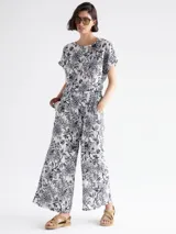 Pantalón palazzo estampado con flores exóticas en tonos azul y blanco.