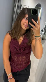 Top de encaje color bordó con cuello volcado y estilo halter. Presenta un diseño entallado con transparencias y terminación de puntilla en el ruedo.