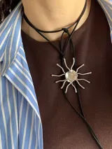 Collar artesanal con dije en forma de sol hecho a mano en bronce y alpaca, suspendido en un tiento de gamuza.