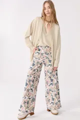 Cardigan color beige con lurex, escote en V, manga larga, botones de pasta, bolsillos delanteros y terminaciones de rib.