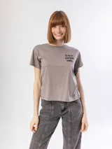 Remera de algodón color verde musgo, con cuello redondo, mangas cortas y estampa frontal con la frase 'thank u, next' en color negro.