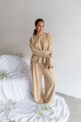 Conjunto de dos piezas de viscosa con estampado de rayas horizontales color tostado y blanco, compuesto por una remera de manga larga oversize y un pantalón ancho de corte recto.