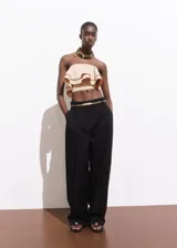 Top strapless de diseño crop, confeccionado en algodón, con detalle de volantes en capas en la parte frontal y cierre de cremallera en la espalda.