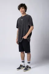 Remera de corte holgado con efecto de lavado ácido en tono gris oscuro. Presenta un pequeño estampado gráfico en el centro del pecho con la inscripción 'ASTRAL ENERGY' y las siglas 'VCP'.