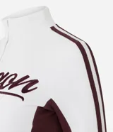 Campera deportiva de corte ajustado, color blanco con paneles laterales y detalles en mangas color bordó. Presenta cierre frontal completo, cuello alto y estampa con lettering 'Oregon' en el pecho.