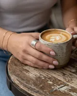 Anillo ancho de acero plateado con diseño texturizado de líneas múltiples y ajuste abierto.