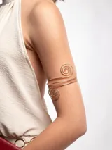 Brazalete dorado para el brazo, con diseño en espiral en ambos extremos y cuerpo de alambre múltiple ajustable.
