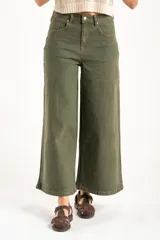 Pantalón wide leg de tiro medio en color verde oliva, confeccionado en tejido de algodón con mezcla de poliéster, liocel y elastano. Presenta diseño de cinco bolsillos, cierre frontal con botón y cremallera, y costuras a tono.