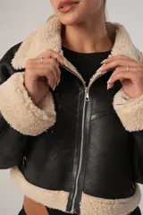 Gamulán corto de cuero sintético color negro con interior de piel sintética color beige.