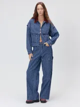 Pantalón de jean marrón de tiro medio, pierna ancha y estilo cargo con bolsillos utilitarios en las rodillas.