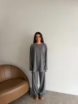 Conjunto oversize de dos piezas en tejido acanalado color beige, compuesto por una remera de manga larga con aberturas laterales y un pantalón largo de corte recto y holgado.