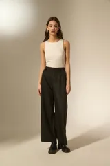 Pantalon de vestir negro con acabado brillante tipo glitter, de corte ancho y tiro alto.