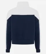 Buzo tipo polo de textura waffle con diseño color block en blanco y azul marino. Presenta cuello alto con cierre de botones, mangas largas y bordados decorativos en el frente.