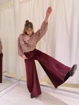 Pantalón de terciopelo color borgoña, de tiro medio y corte acampanado.