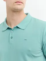 Remera polo azul marino de manga corta, con cuello y tapeta de dos botones. Presenta aberturas laterales en el dobladillo.