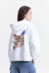 Canguro blanco de felpa con capucha ajustable, bolsillos frontales tipo canguro y estampado en frente y espalda.