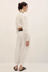 Pantalón babucha negro de lino, de corte holgado estilo barrel con pinzas en la cintura y bolsillos laterales.