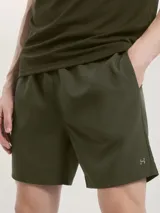 Bermuda deportiva de corte recto y largo medio, confeccionada en tejido técnico ligero de color verde oliva. Cuenta con cintura elástica y bolsillos laterales.