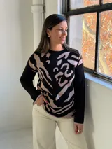 Sweater de tejido de punto con diseño estampado abstracto en tonos negro y beige, de cuello redondo y manga larga.