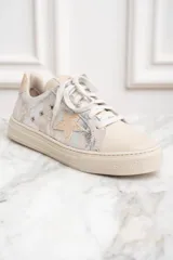 Zapatillas bajas de cuero color crema con detalles plateados y estrella lateral.