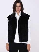 Chaleco negro de piel sintética con diseño de trenzas y cuello tipo camisa.