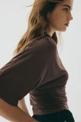 Top de punto elástico color marrón chocolate, con cuello alto, mangas al codo y diseño con fruncidos laterales que generan un efecto drapeado.
