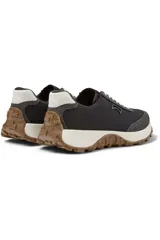 Championes Camper D.Trail.864 en color gris oscuro con refuerzos de gamuza, cordones blancos y suela dentada de goma marrón con entresuela blanca.