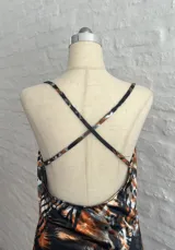 Minivestido ajustado con estampado animal print en tonos naranja, marrón y negro. Diseño con escote drapeado con detalle de encaje negro y tirantes finos.