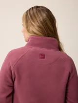 Sweater de polar con medio cierre frontal, cuello alto y mangas largas. Presenta un diseño liso en color azul petróleo con un pequeño logo bordado en el pecho.