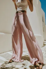 Pantalón fluido de tiro alto con cintura elástica y pernera ancha, de color rosado.