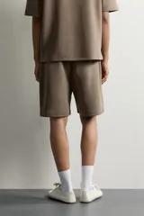 Bermuda estilo jogger de ajuste relajado, confeccionada en tejido interlock de algodón. Cuenta con cintura elástica ajustable con cordón, bolsillos frontales de vivo y diseño liso.