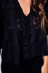 Blusa negra de algodón peinado con calce oversize, escote en V, mangas tres cuartos abullonadas y detalles de encaje y bordados en el frente y mangas.