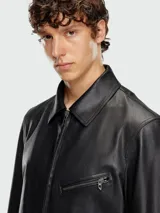 Campera de cuero negro con cierre frontal, cuello camisero y bolsillos con cierre en el pecho y laterales.