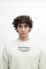 Buzo celeste de corte holgado con cuello redondo y puños y cintura acanalados. Estampado frontal con texto "Sunset Whispers" en color azul.