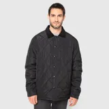 Chaqueta acolchada de diseño romboidal en color negro, con cuello camisero de textura aterciopelada y cierre frontal mediante botones a presión.