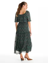 Vestido midi de gasa estampada con diseño de hojas, escote en V cruzado y mangas cortas fluidas. Presenta cintura elastizada con lazo ajustable y falda con volados escalonados que aportan movimiento. Incluye forro interno a tono.